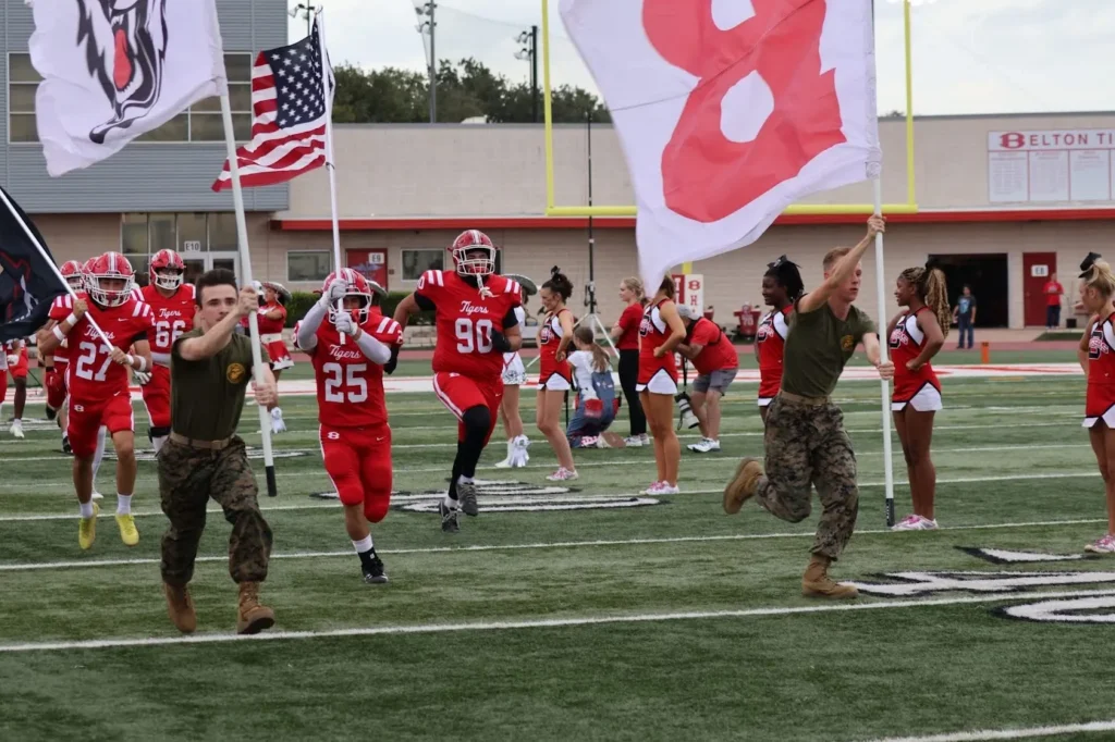 highschool football players entering the field