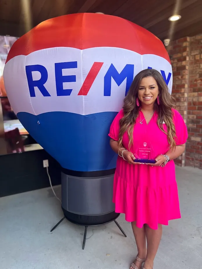 mallory anthony in front of a remax ballon